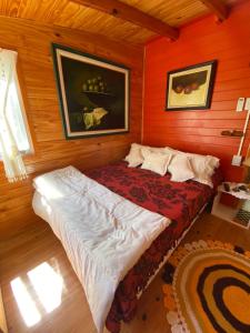 a bedroom with a bed in a wooden room at Cabaña La Paz in Tigre