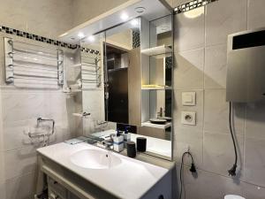 a white bathroom with a sink and a mirror at Résidence Bero Bisto - maeva Home - Appartement 2 Pièces 6 personnes - Confort MAE-0191 in La Mongie