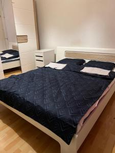 a bedroom with a bed with a black comforter at Motel Schwanen in Schlattingen