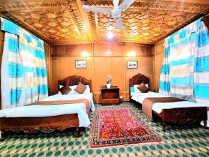 a room with two beds with curtains and a rug at Ali jan hotel in Srinagar