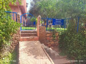 a blue gate with a sign in front of a building at Maison Touria in Ouzoud