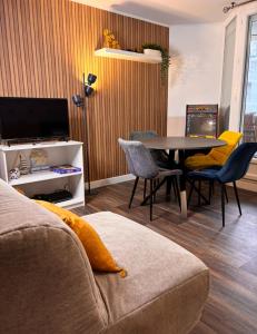 a living room with a couch and a table and chairs at Cosy Home Next To Disneyland & Train in Torcy