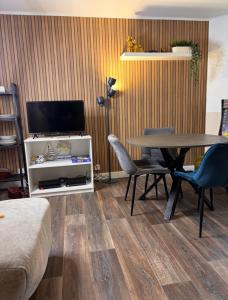 a living room with a table and a tv at Cosy Home Next To Disneyland & Train in Torcy