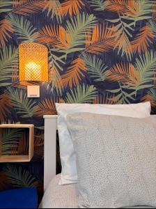a bedroom with a bed and a tropical wallpaper at Cosy Home Next To Disneyland & Train in Torcy