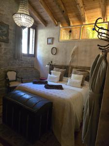 a bedroom with a large bed with a chandelier at El Racó dels Mussols 2 in Adri +70 photos