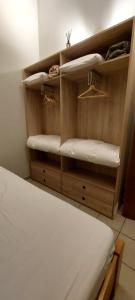 a room with a bed and shelves with towels at Maison Aunais in Mormont-La-Grande