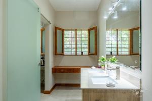 a bathroom with two sinks and a large mirror at Casa Mapache Pool and Breakfast Included near Tamarindo Beach in Tamarindo