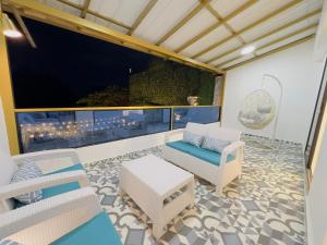 a balcony with chairs and a large screen television at Mansion Parque Lleras Poblado Medellin in Medellín