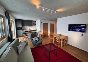a living room and kitchen with a couch and a table at Bungalow Laroo in Ried im Oberinntal