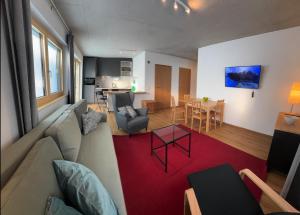 a living room with a couch and a red rug at Bungalow Laroo in Ried im Oberinntal