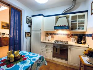 a kitchen with white cabinets and a stove top oven at I Pini House in Magione
