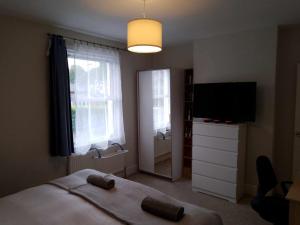 a bedroom with a bed and a flat screen tv at Double or twin room in town centre in East Grinstead +62 photos