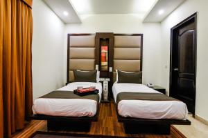 two beds in a small room with at Hotel O Venkata Sai Sadan Mathrusree Nagar in Hyderabad
