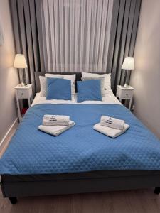 een slaapkamer met een blauw bed met 2 kussens erop bij Rewal Cliff Morska 2 in Rewal