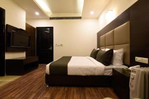 a hotel room with a bed and a television at Hotel O Venkata Sai Sadan Mathrusree Nagar in Hyderabad