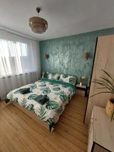 Un dormitorio con una cama con una pared verde. en Urban Luxury Escape, en Piatra Neamţ