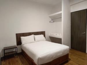 a bedroom with a large bed with white sheets at Hostal Schultz in Mexico City