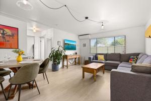 a living room with a couch and a table at Bayswell by Experience Jervis Bay in Huskisson