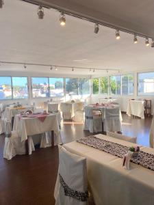 una sala da pranzo con tavoli bianchi e sedie bianche di Hotel Centro a Piriápolis