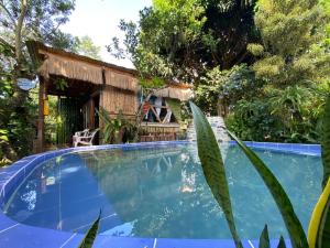 a swimming pool in front of a house with trees at Villa Sonia Eco-Hostel in Gigante