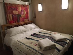 a bedroom with a bed with two towels on it at Pathways, Beachwood Cottage in Bath