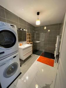 a washing machine in a bathroom with a washer at Jacuzzi privé 500m de la mer in Blainville-sur-Mer +10 photos