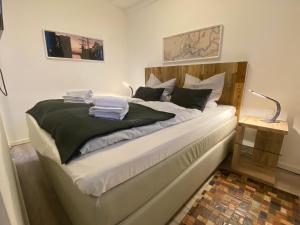 een slaapkamer met een groot bed met witte lakens bij Meerblick, Balkon und private Sauna im historischen Getreidespeicher in Wismar