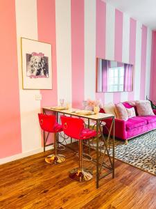 a living room with a table and red chairs at Dolly's Delight - Boutique Bliss Mins From Broadway in Nashville