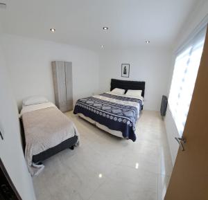 two beds in a white room with a window at Mate 2 in Río Gallegos