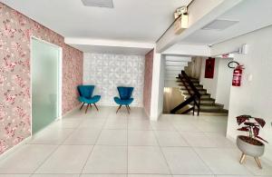 a hallway with two blue chairs and a staircase at João Machado Fortes in Florianópolis