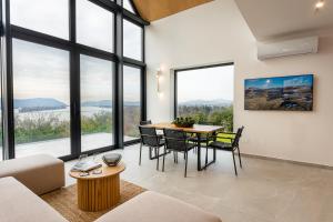 a living room with a table and chairs and large windows at Zebegény 233 in Zebegény