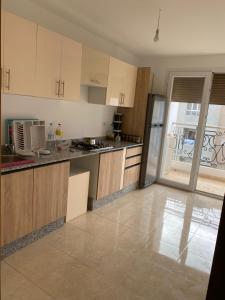 a kitchen with wooden cabinets and a stainless steel refrigerator at Appartement haute standing in Selouane