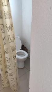 a bathroom with a toilet and a shower curtain at Discovery Guest House in Roodepoort