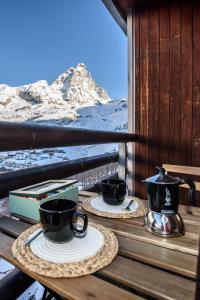 two cups of coffee sitting on a table on a balcony at Erikzang - Cervinia Ski in Ski out Apartments in Breuil-Cervinia