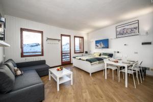 a living room with a couch and a bed and a table at Erikzang - Cervinia Ski in Ski out Apartments in Breuil-Cervinia