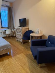 un soggiorno con un divano blu e una TV di Restauracja Hotel Ostoja a Wieniawa