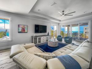 a living room with a couch and a tv at Sunrise Hideaway - Ocean View Luxury Pool Home - 350 Feet to the Beach in New Smyrna Beach