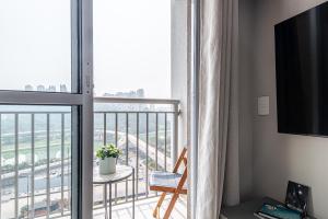 a room with a balcony with a view of a city at Laguna 1809 - Seu espaço em SP in Sao Paulo