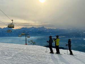 three people on a ski slope with a ski lift at EULIUM - Retreat Chalet in Arriach