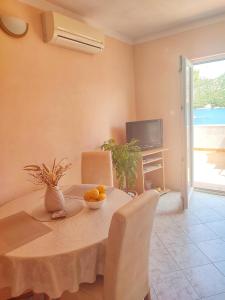 a dining room with a table with a bowl of fruit on it at Apartments Vesna in Lastovo