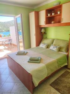 a bedroom with a large bed with two towels on it at Apartments Vesna in Lastovo