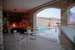 a patio with a fireplace and a table and chairs at House Sika in Miškovići