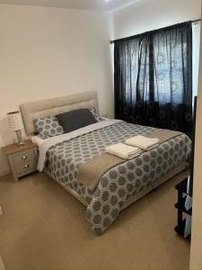 ein Schlafzimmer mit großem Bett und Fenster in der Unterkunft Central Town Apartment in Kent