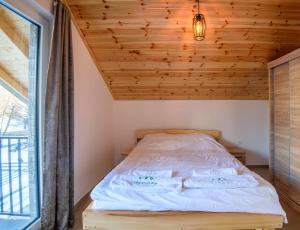 a bed in a room with a wooden ceiling at Villat Morina Boge in Boge