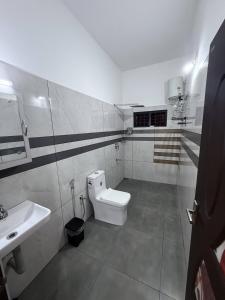 a bathroom with a white toilet and a sink at Luxury Villa Ps5 Home-Theater Hookah 30km 2 Munnar in Chillithodu +29 photos