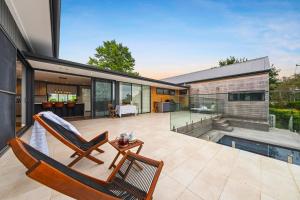 a patio with two chairs and a swimming pool at Magnolia House in Kurrajong