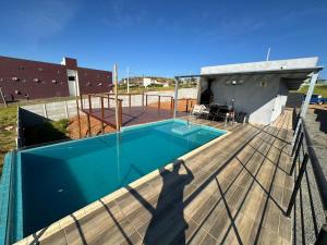 a swimming pool on the deck of a house at Casa com piscina Capitólio in Capitólio