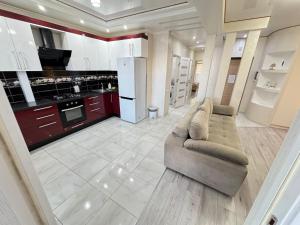 a living room with a couch and a kitchen at For Family Full Apartment near AirPort in Chişinău