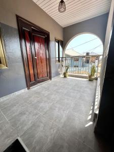 アクラにあるThe Leisure Placeのドアとパティオ付きの空の部屋