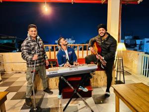 a group of three men standing around a keyboard at GreenDay Escapes Rishikesh in Rishīkesh